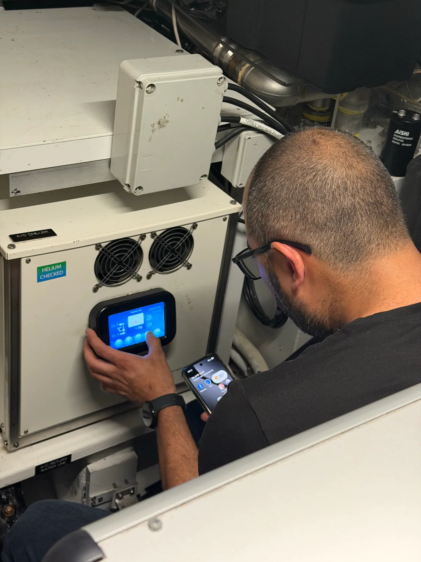 HOSS AC technician servicing the marine A/C chiller aboard a 100 ft yacht in Fort Lauderdale